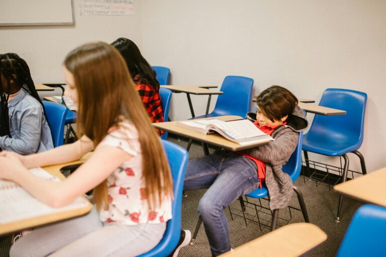 Students engaged in learning activities in a classroom setting, showcasing diversity.